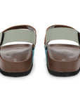 Pair of sandals with a light green strap and brown sole on a white background