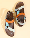 Pair of sandals with brown leather and colorful straps on a beige background