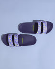 Pair of Mimo purple slides with floral straps on a light blue background