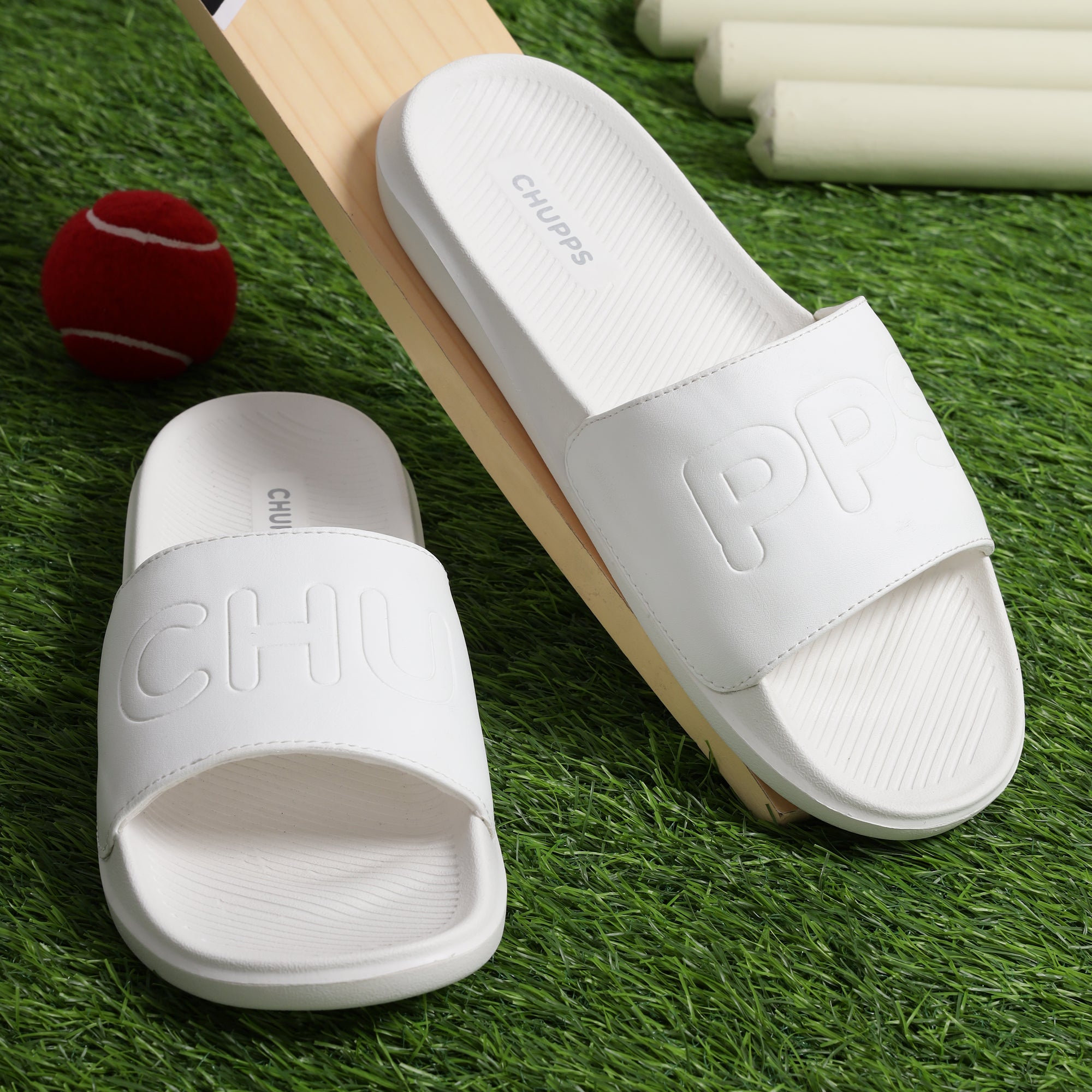 White sliders for men with cushioned AirSoft Sole on a green background