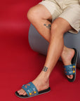 Phantom sliders with cutout design and patterned straps, on a red background